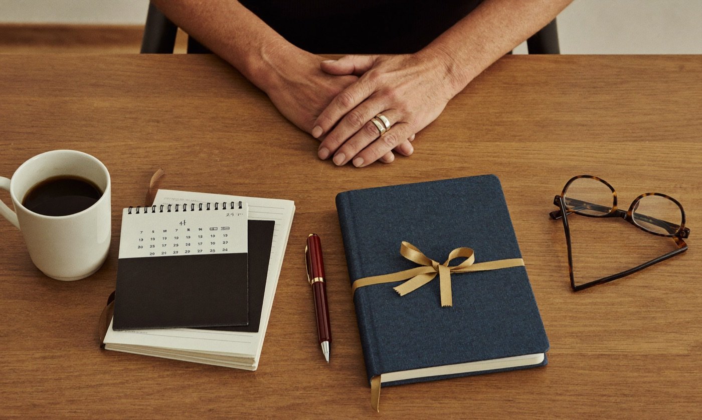 Reading glasses and a notebook on a tidy desk